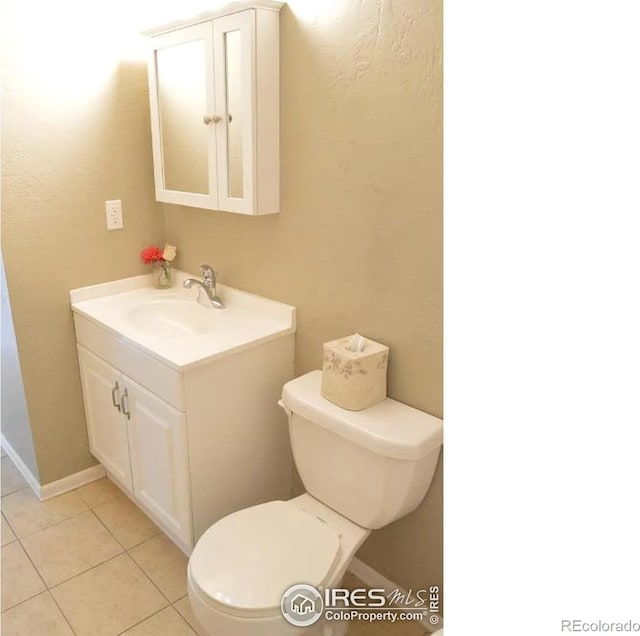 half bath featuring toilet, tile patterned flooring, and vanity