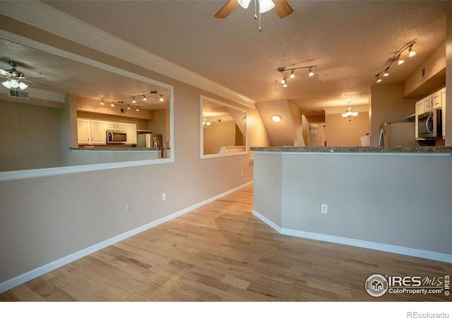 2092 N Concord Ln, Superior, CO 80027 - kitchen with rail lighting, ceiling fan, stainless steel appliances, light wood-style flooring, and a textured ceiling