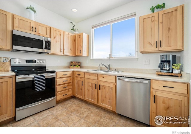 kitchen with stainless steel appliances, a sink, light brown cabinets, light countertops, and recessed lighting