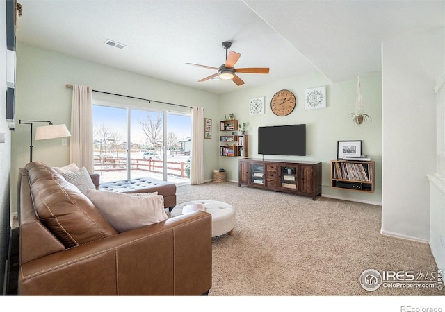 carpeted living room featuring ceiling fan and baseboards