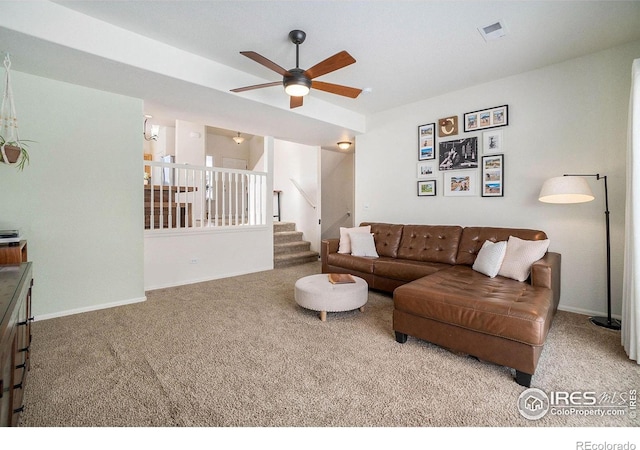 carpeted living area featuring a ceiling fan, stairway, and baseboards