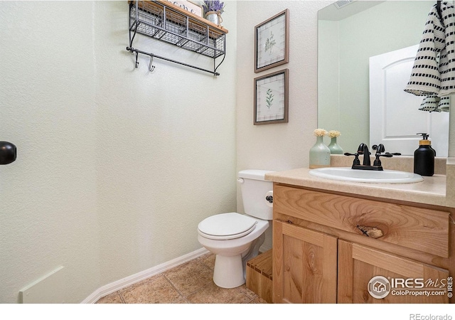 bathroom with toilet, tile patterned flooring, and vanity