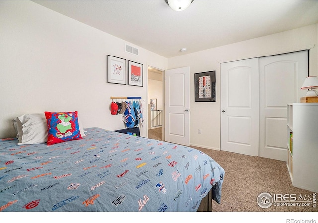 carpeted bedroom with a closet and baseboards