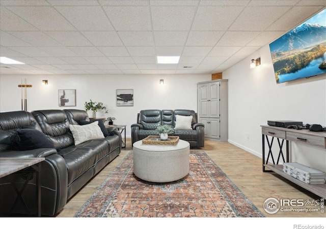 7726 Kit Fox Dr, Wellington, CO 80549 - living area featuring light wood finished floors, a paneled ceiling, and baseboards