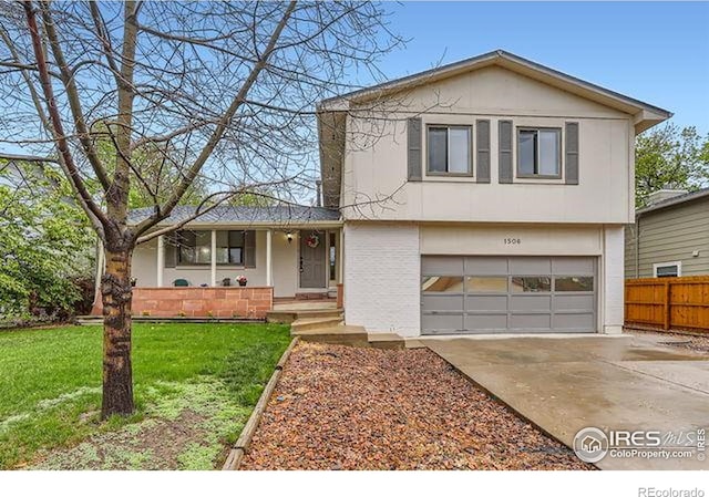split level home featuring an attached garage, concrete driveway, covered porch, and brick siding