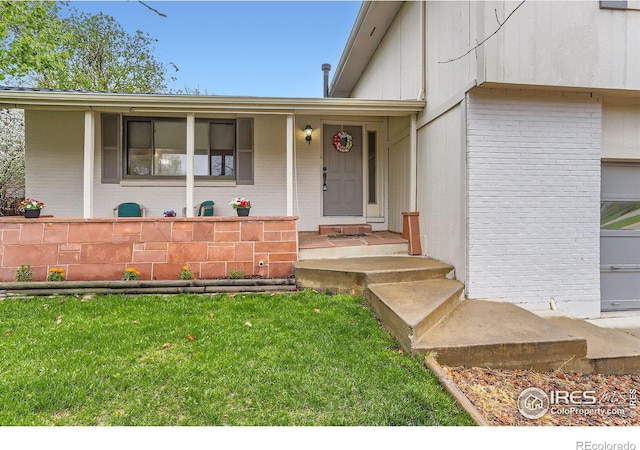 property entrance with brick siding and a lawn