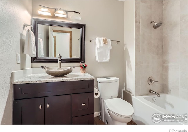 bathroom featuring toilet, vanity, and shower / bathtub combination
