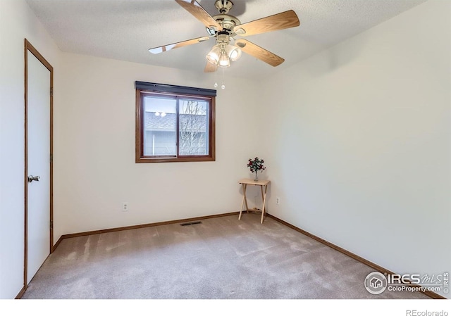 unfurnished bedroom featuring carpet, baseboards, ceiling fan, and a textured ceiling