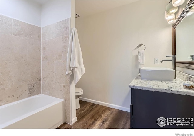 full bathroom featuring wood finished floors, vanity, toilet, and baseboards