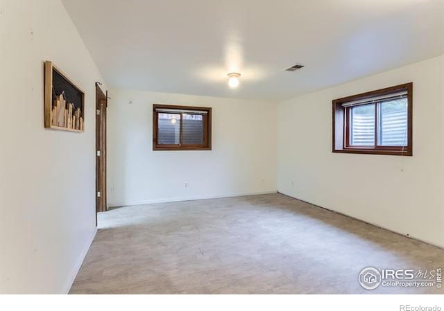 empty room with baseboards and light carpet