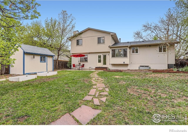 back of house with an outbuilding, a patio, and a shed