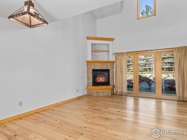 865 Crabapple Ln, Estes Park, CO 80517 - unfurnished living room with wood finished floors, a tile fireplace, baseboards, and high vaulted ceiling