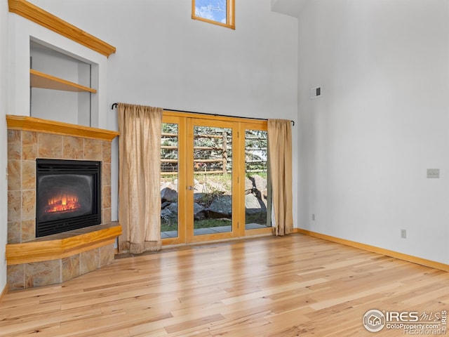 865 Crabapple Ln, Estes Park, CO 80517 - unfurnished living room featuring a towering ceiling, wood finished floors, a fireplace, and baseboards