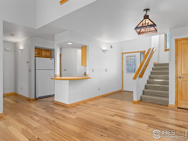 865 Crabapple Ln, Estes Park, CO 80517 - kitchen with freestanding refrigerator, baseboards, light wood-type flooring, and a peninsula