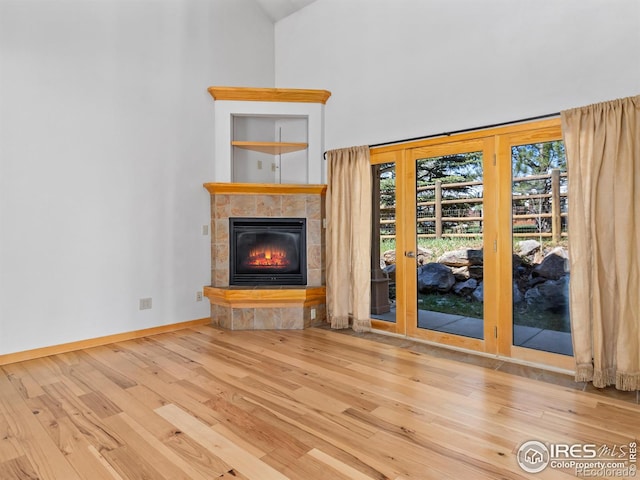 865 Crabapple Ln, Estes Park, CO 80517 - unfurnished living room featuring wood finished floors, french doors, high vaulted ceiling, a fireplace, and baseboards