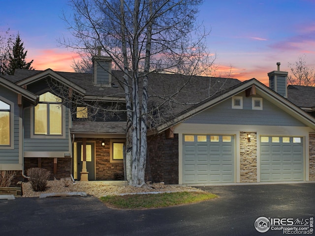865 Crabapple Ln, Estes Park, CO 80517 - view of front facade with a chimney, asphalt driveway, and an attached garage
