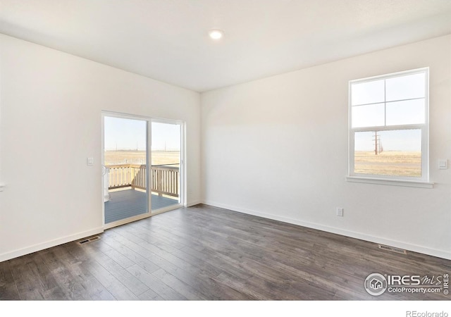 spare room with dark wood finished floors, baseboards, and recessed lighting