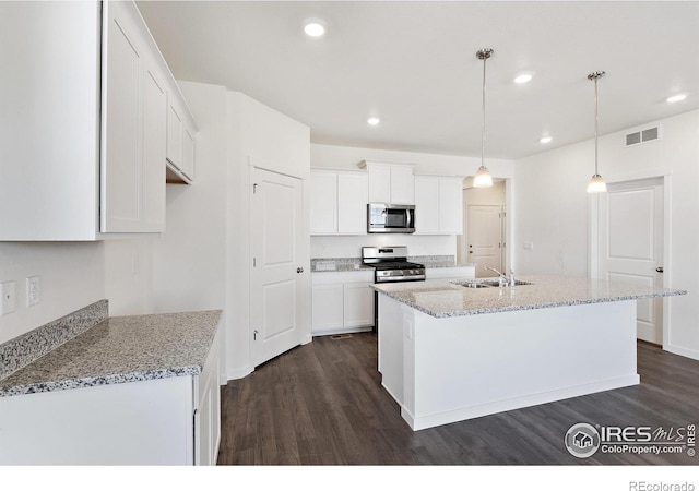 kitchen with stainless steel appliances, a sink, dark wood-type flooring, white cabinetry, and recessed lighting