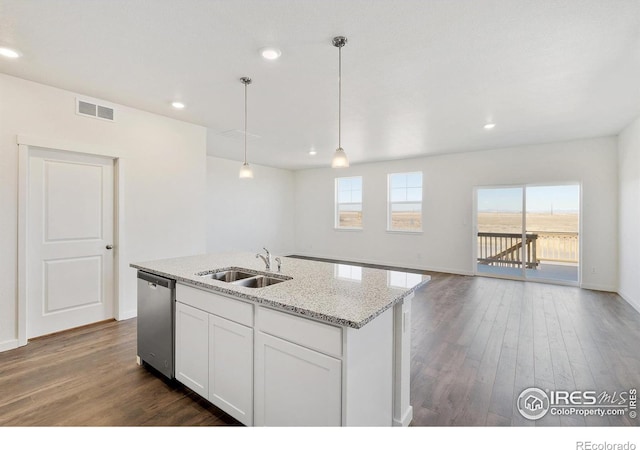 kitchen with dishwasher, a sink, dark wood-style floors, a kitchen island with sink, and light stone countertops