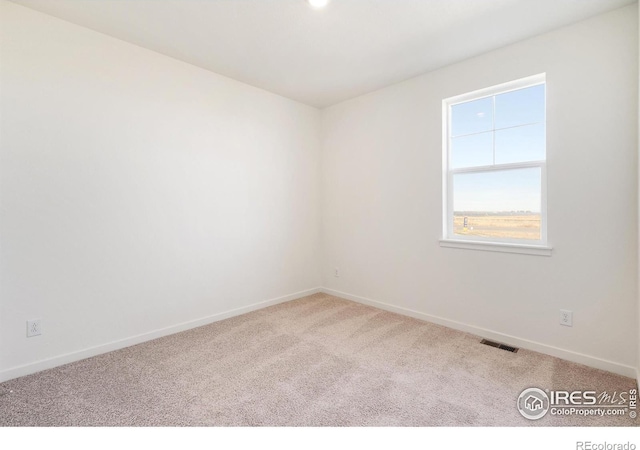 carpeted spare room with baseboards