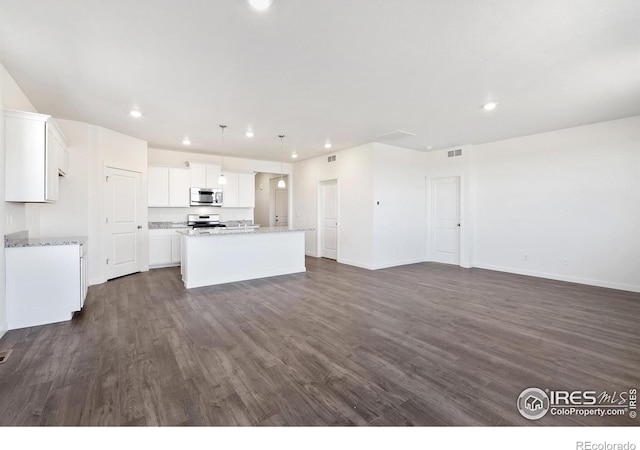 kitchen featuring stainless steel appliances, an island with sink, dark wood-type flooring, recessed lighting, and white cabinets