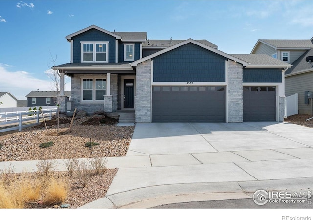 4532 Big Horn Pkwy, Johnstown, CO 80534 - view of front facade featuring an attached garage, fence, stone siding, concrete driveway, and covered porch