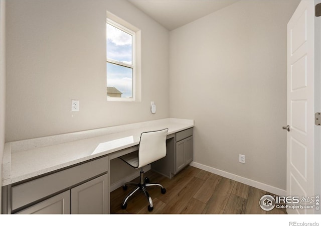 4532 Big Horn Pkwy, Johnstown, CO 80534 - unfurnished office with built in desk, wood finished floors, and baseboards