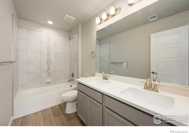 4532 Big Horn Pkwy, Johnstown, CO 80534 - full bathroom with toilet, wood finished floors, double vanity, tub / shower combination, and recessed lighting