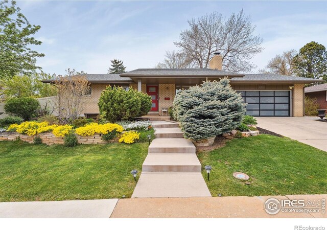 2001 James Dr, Loveland, CO 80538 - view of front of home with an attached garage, driveway, a front lawn, and brick siding