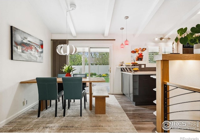2001 James Dr, Loveland, CO 80538 - dining area featuring beam ceiling, healthy amount of natural light, wood finished floors, and baseboards