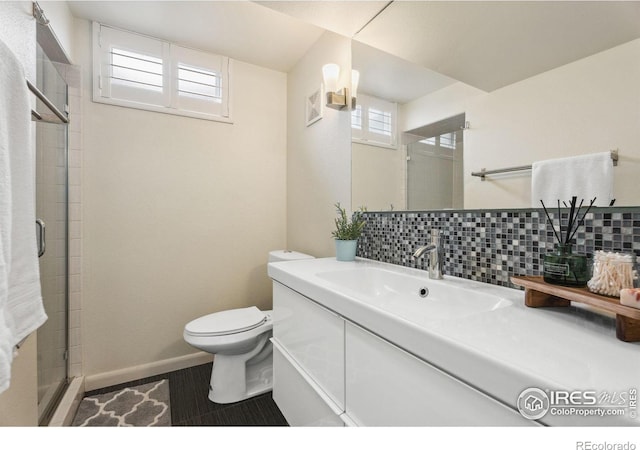 2001 James Dr, Loveland, CO 80538 - full bath with toilet, a shower stall, decorative backsplash, vanity, and baseboards