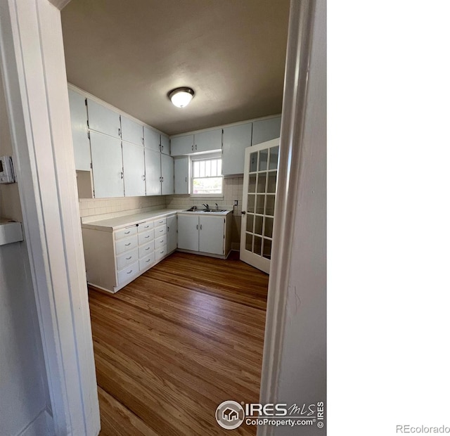 1219 16th St, Greeley, CO 80631 - kitchen with dark wood finished floors, light countertops, tasteful backsplash, and white cabinets