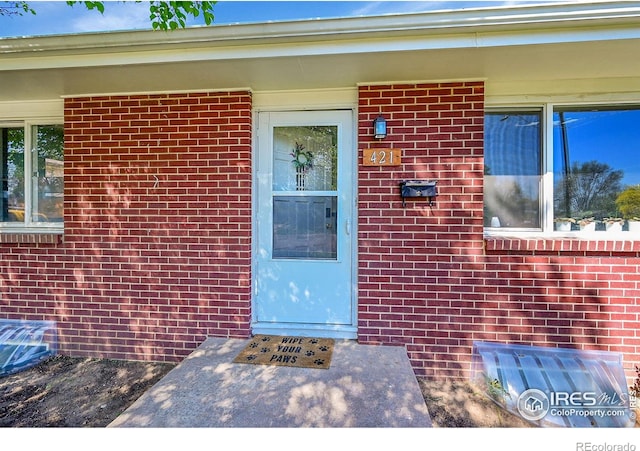 doorway to property with brick siding