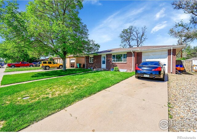 ranch-style house featuring concrete driveway, a garage, brick siding, and a front yard