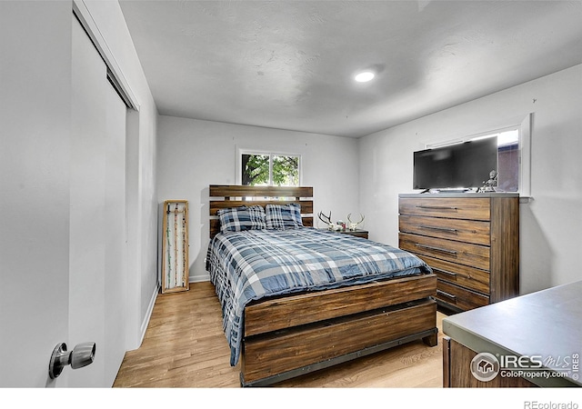 bedroom with light wood-style flooring and baseboards