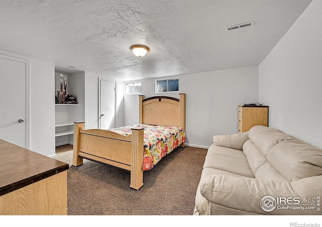 bedroom with carpet floors, baseboards, and a textured ceiling