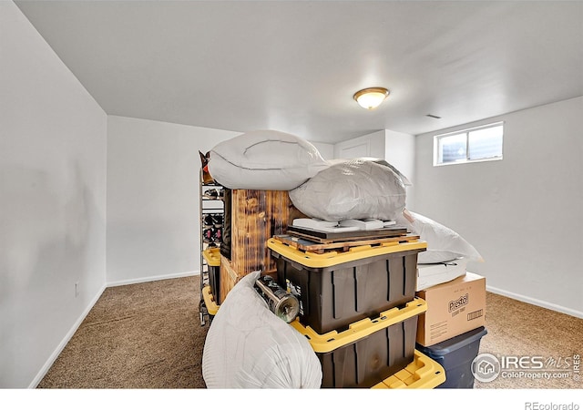 below grade area featuring carpet flooring and baseboards