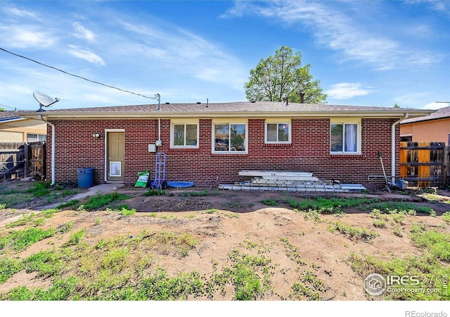back of house with fence and brick siding