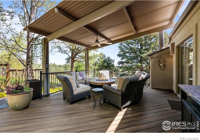 wooden deck featuring an outdoor living space with a fire pit