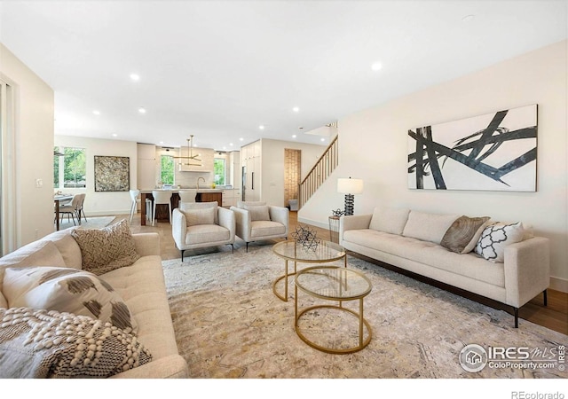 living area featuring recessed lighting, baseboards, and stairs