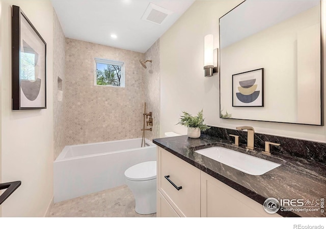 bathroom featuring toilet, vanity, and tub / shower combination