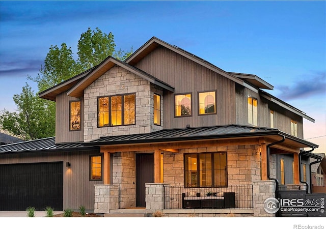 view of front of property with covered porch, a standing seam roof, stone siding, and metal roof