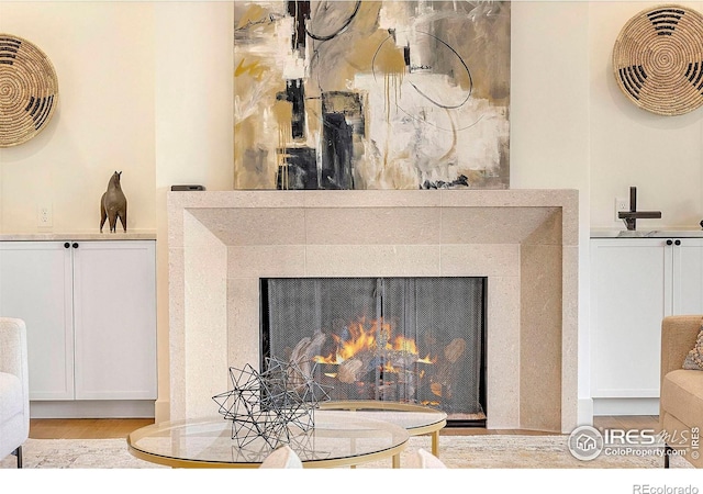 detailed view of wood finished floors and a lit fireplace