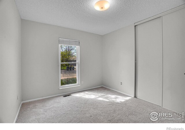 1201 Stein St, Lafayette, CO 80026 - unfurnished bedroom featuring carpet flooring, a textured ceiling, a closet, and baseboards