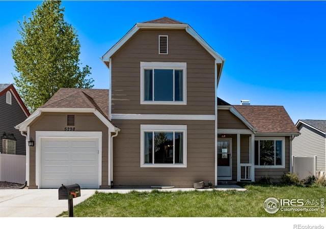 traditional home featuring a garage, driveway, and roof with shingles