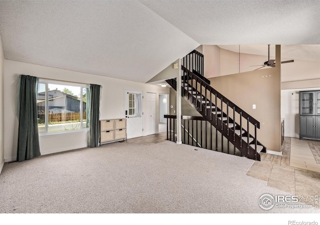 unfurnished living room featuring carpet flooring, ceiling fan, stairway, a textured ceiling, and baseboards