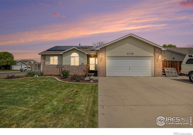 5049 W 2nd Street Rd, Greeley, CO 80634 - ranch-style home featuring brick siding, roof mounted solar panels, a garage, and driveway