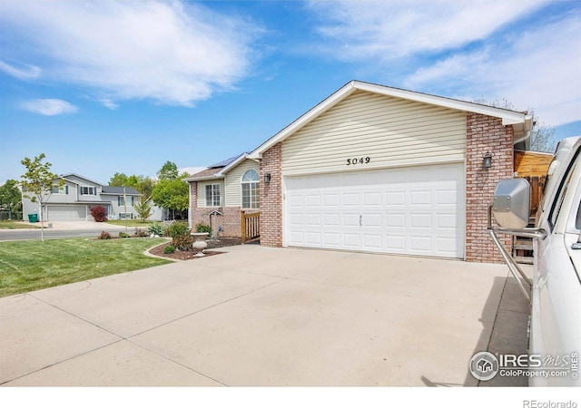 5049 W 2nd Street Rd, Greeley, CO 80634 - single story home with brick siding, an attached garage, concrete driveway, and a front yard