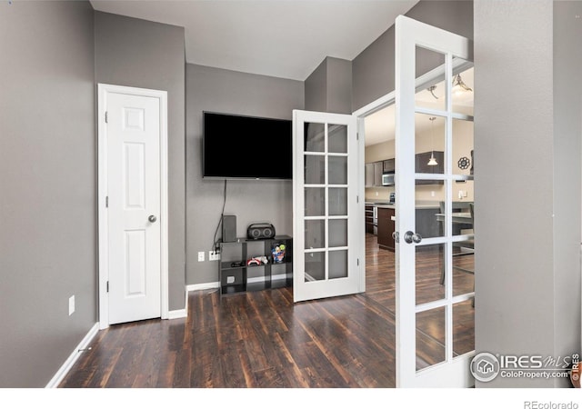 home office with wood finished floors, french doors, and baseboards