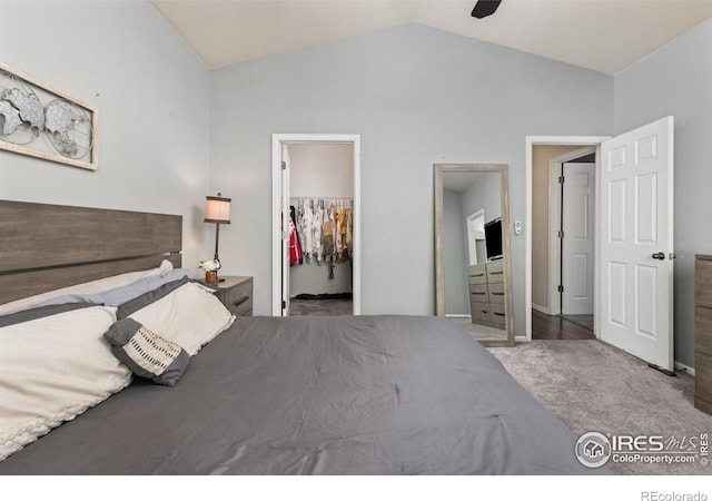 bedroom with a spacious closet, lofted ceiling, carpet, a closet, and a ceiling fan